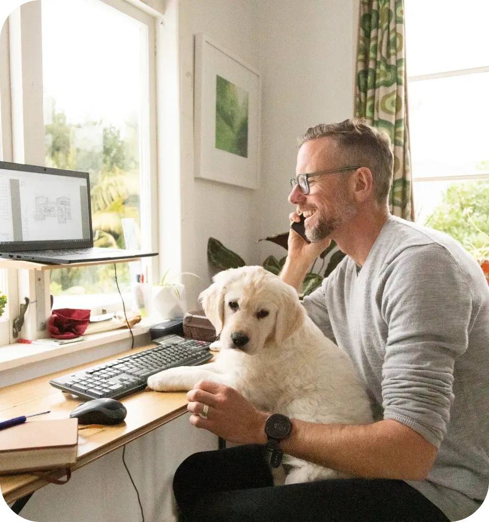 Man working on laptop with dog